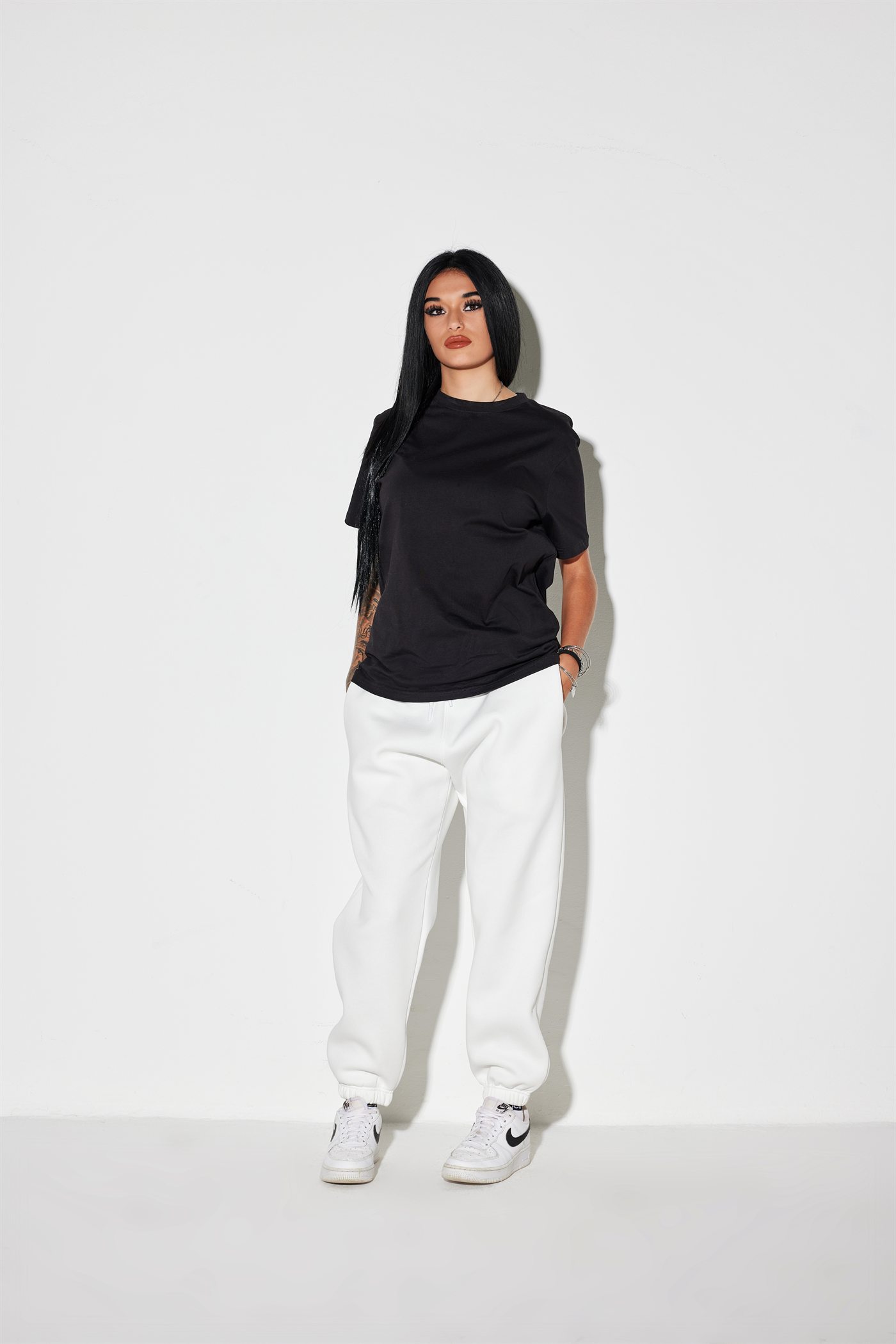 Modella Sassolini con maglia nera e pantaloni bianchi — capo Made in Italy della collezione